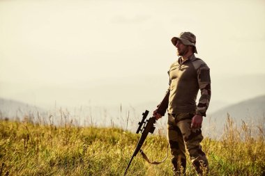 Odaklanma ve konsantrasyon deneyimli avcı. Acımasız savaşçı. Avlanma tüfeği. Avcı tüfeği. Hunter Dağları manzara arka planı. Çekime hazırız. Ordu kuvvetleri. Silahlı asker kıyafetleri.