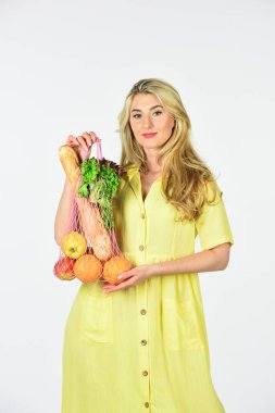 Marketten. Market poşeti. Yeniden kullanılabilir eko çanta. Bilinçli tüketim. Çevre trendi. Sıfır atık. Elinde meyve dolu bir torba tutan kadın. Elbiseli kız çanta alışverişi yapıyor. Yeniden kullanılabilir çanta