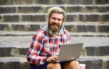 İnternette çalışıyorum. Hippi şehir uzayı için ilham kaynağı oldu. Modern laptop. Uzaktan kumanda. Son teslim tarihi geldiğinde. Temiz hava. Gezici internet. Çevik iş. Sakallı adam arka planda oturuyor. Çalış ve rahatla