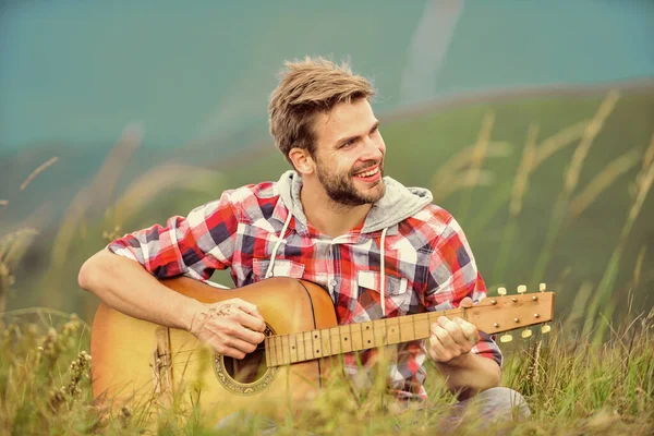 Wanderlied. Mann mit Gitarre auf dem Gipfel des Berges. Inspirierter Musiker. Sommer-Musikfestival im Freien. Die Stille der Berge und der Klang der Gitarrensaiten. Hipster-Musiker. Inspirierendes Umfeld — Stockfoto