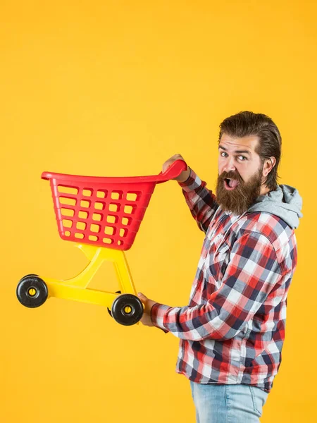 Homem barbudo ir às compras com carrinho de compras vazio brinquedo. cliente empurrando carrinho. comprador no supermercado. carrinho de brinquedo vazio. Uma governanta muito ocupada. marido perfeito. lista de compras necessidade — Fotografia de Stock