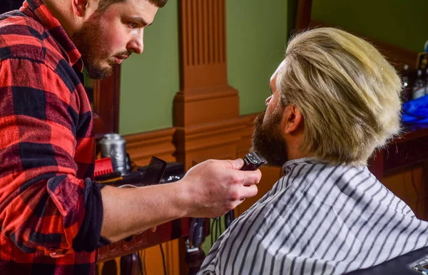 Cortar la barba. Una rutina de belleza. Mantener la forma. El hombre se sienta silla de barbero. Peluquería. Cliente de barbería. Servicios de peluquería. Excelente peluquero no se apresura corte de pelo. Visita peluquería — Foto de Stock