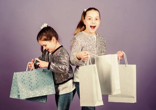 Sexta-feira negra. Venda e desconto. Dia das compras. Pacotes de crianças. Moda infantil. Meninas irmãs amigos com sacos de compras fundo violeta. Porque a imagem é tudo. Compras e compras — Fotografia de Stock