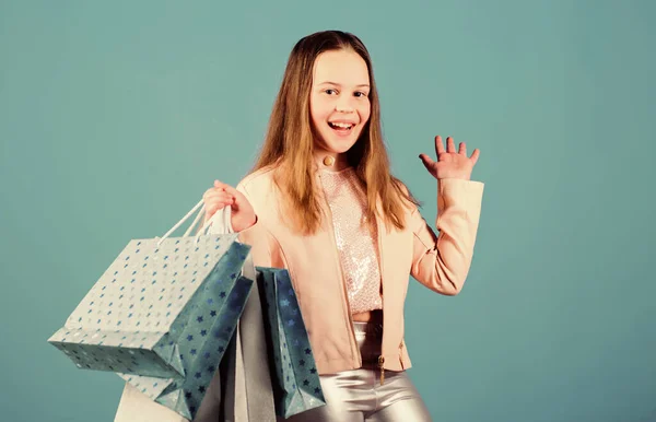 Alla moda infantile. commessa con pacco. Saldi e sconti. Ragazzina con borse della spesa. Un bambino felice. Ragazzina shopping online. risparmi sugli acquisti. moda per bambini. Negozio di bambini. stile di moda — Foto Stock