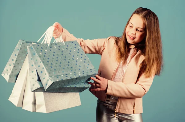 Nice purchase. Happy child. Little girl with gifts. Sales and discounts. Holiday purchase saving. Kid fashion. shop assistant with package. Small girl with shopping bags. purchase bags in hand of kid Stock Image