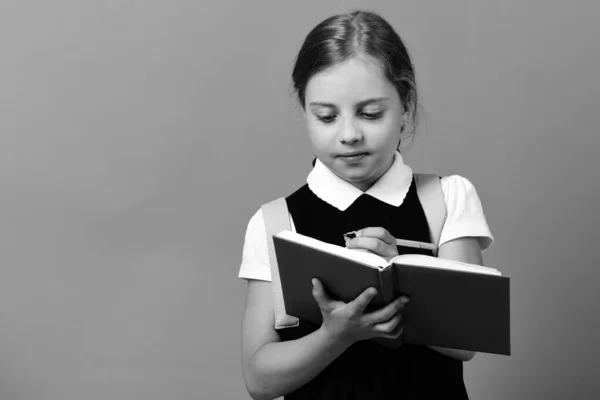 Menina da escola com expressão facial atenta no fundo azul — Fotografia de Stock