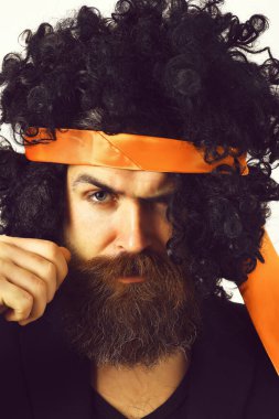 Takım elbiseli beyaz tenli hippi ve siyah kıvırcık saçlı peruk.