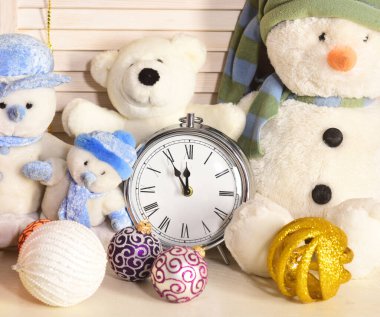 Şimdi adamlar, oyuncak ayılar ve Noel ağacı topları çalar saatin yanında.