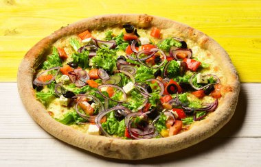 Domatesli pizza, peynir, salata ve kırmızı soğan.