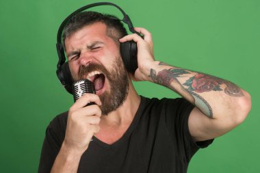 Sakallı ve heyecanlı yüzlü şarkıcı müzik dinliyor..