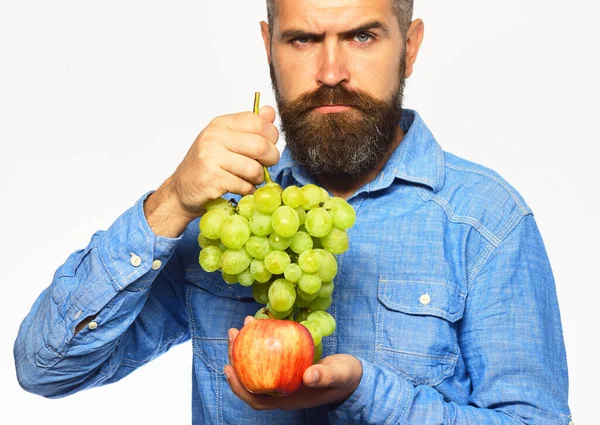 턱수염을 한 남자가 푸른 포도와 사과를 한 다발들고 있다 — 스톡 사진