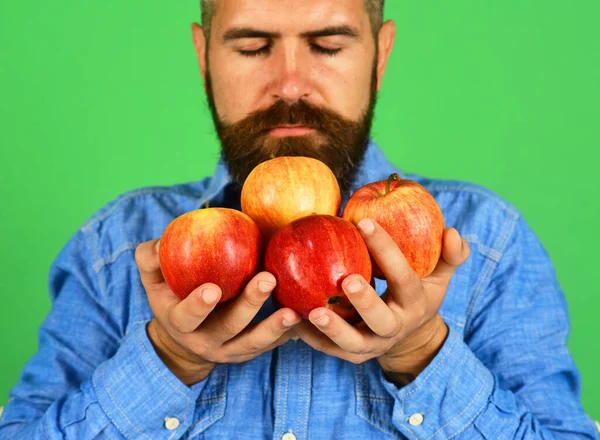 Agricultor con los ojos cerrados y las manos llenas de manzanas frescas — Foto de Stock