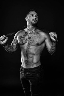 Fitness modeli üstsüz. Sağlık hizmeti yaşam tarzı. Vücut kasları güçlü. Vahşi erkeksi güzellik. Maço. vahşi ve seksi. Vücut dövmesi olan kaslı bir vücut geliştirici. Atletik erkek güçlü bir kemer tutuyor. Güç dolu.