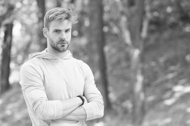 Kendinden emin ve fiziksel olarak fit. Kendine güvenen sporcu kollarını açık havada kavuşturur. Kaslı bir adamın kendine güveni. Atletik bir tip. Kendinden emin ve sağlıklı. Spor eğitimi ve antrenman. Gurur duy.