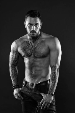 Baştan çıkarıcı bir bakış. Dövmeli sakallı bir adam. Maço seksi çıplak gövde. Cildinde dövme resmi olan uygun bir model. Sakallı ve saçlı sporcu ya da sporcu. Spor ve spor. Erkeklik. Kas gövdesi