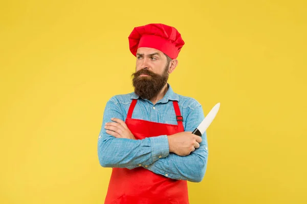 Eten speciaal maken. zelfverzekerde bebaarde chef-kok rood uniform. Mannelijke chef met mes gesneden. volwassen hipster met serieus gezicht. De bebaarde chef kruiste de handen. brutale slager in schort. beste menu aanbod — Stockfoto