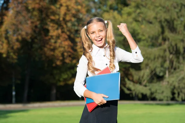 Und der Gewinner ist es. Glückliche Gewinner feiern im Freien. Kleines Kind macht Siegergeste. Studienerfolg. Stipendiatin. Zurück zur Schule. Gewinner bekannt gegeben. Glückwunsch — Stockfoto