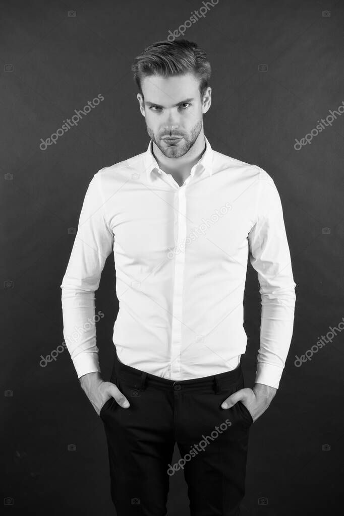 Wear it simple. White shirt and black pants. Serious man dark background. Fashion look of handsome guy. Fashion model in classic style. Fashion and style. Ready to go fashion wardrobe