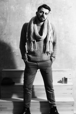 Duvarın arkasında ciddi bir yüzü olan sakallı bir adam.