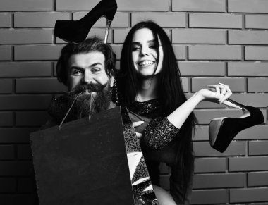 Sakallı adam ve alışveriş çantası, ayakkabıları olan seksi kadın.