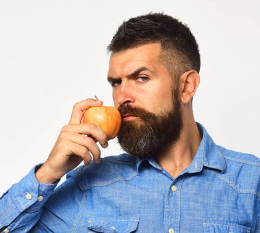 Sakallı adam beyaz arka planda kırmızı meyveler tutuyor.