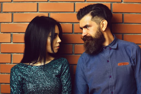 Бородатый мужчина и довольно сексуальная женщина на кирпичной стене — стоковое фото