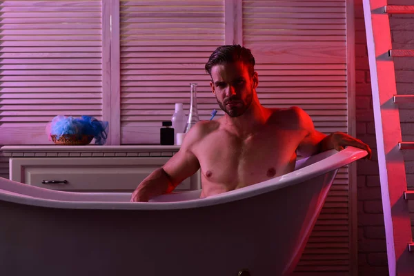 Macho sitzt nackt in Badewanne mit verführerischem Blick — Stockfoto