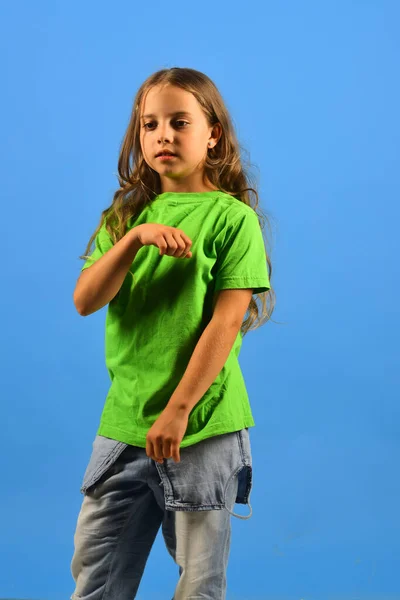 Κορίτσι με σοβαρό πρόσωπο σε μπλε φόντο. Παιδική ηλικία και στυλ — Φωτογραφία Αρχείου