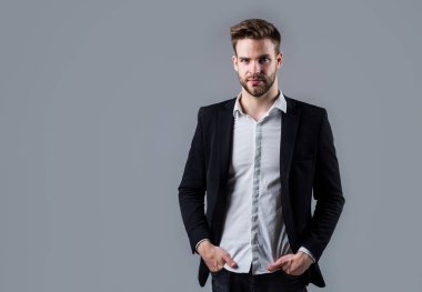 Gömlek ve ceket giyen kendine güvenen bir iş adamı. patron erkek. Gri arka planda seksi CEO. Modern ofis hayatı. Karizmatik iş sahibi. Şık bir emlakçı. Yakışıklı adam resmi takım elbise giyer. Boşluğu kopyala