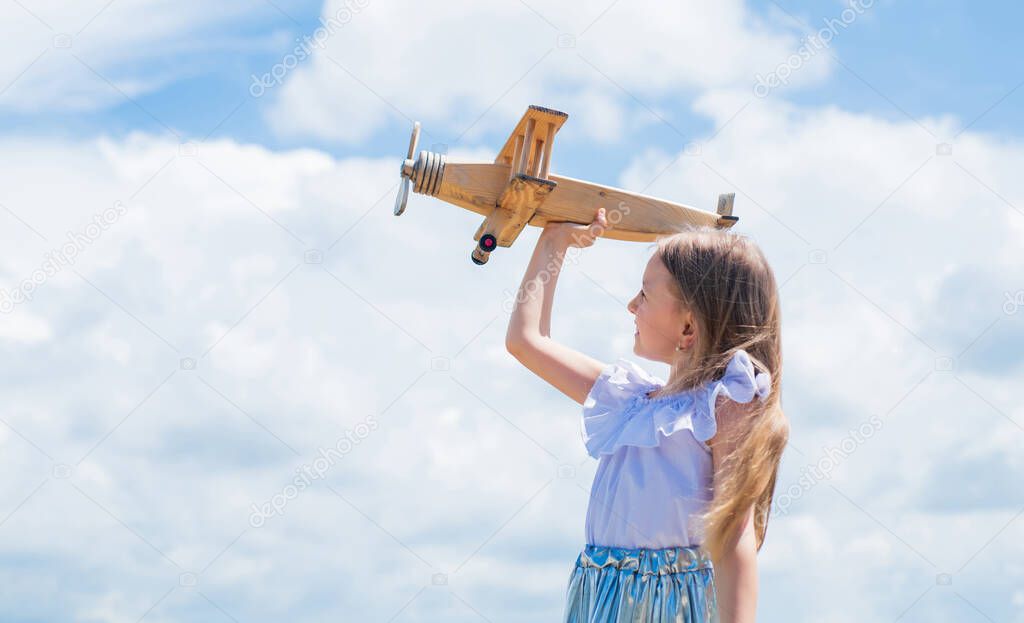 Travel by plane. Keep dreaming. kid play wooden toy airplane. Study geography. Dreams about travel. Story about summer vacation. small girl hold wooden plane. imagination