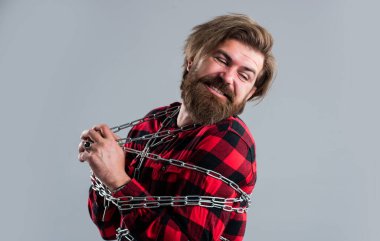 Çırpınıyor. Vücudunda güçlü metal zincirler olan beyaz bir adam. Sakal zinciri olan yakışıklı bir adam. Özgürlük kavramı. Adam zincirlenmiş sorunlar. Kölelikten kurtulmak. Özgür olmak istiyorum.