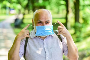 Kilitleme kısıtlamalarını gevşetiyorum. Maske virüsten korunuyor. Yaşlı insanlar yüksek riskli covid-19. Maske tak. Karantina genişletildi. Salgın hastalık konsepti. Enfeksiyonun yayılma riskini sınırla. Kıdemli adam maskesi.