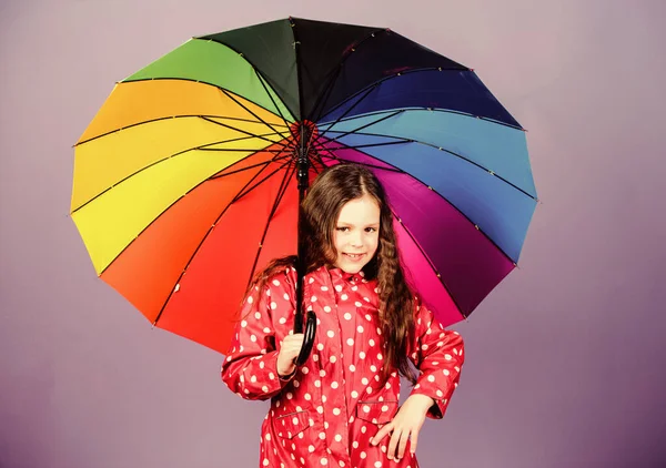 Una ragazzina con l'impermeabile. protezione contro la pioggia. Arcobaleno. moda autunno. allegro bambino hipster di umore positivo. felice bambina con ombrello colorato. Bella giornata. Aria fresca e vista perfetta — Foto Stock