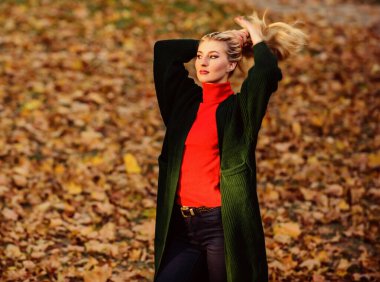 Saçları ne kadar hızlı ve güvenli bir şekilde beyazlatılmış. Kıvırcık saçlardan korunmak için sonbahar saç bakımı önemlidir. Sonbahar parkında şık sarışın kız yürüyüşü. Uzun saç bakım konsepti. Soğuk sarı renk konsepti