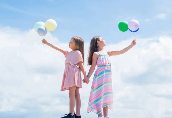 Feliz infancia. vacaciones de verano. Las niñas pequeñas abrazan. amor y apoyo. concepto de hermandad y amistad. tiempo de vinculación familiar. mejores amigos con globo. dos hermanas celebrar fiesta globo — Foto de Stock