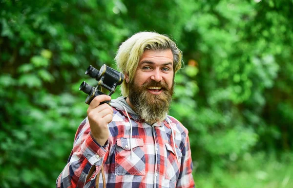Tourism summer vacation. Hobby and leisure. Observing nature. Guy explore environment. Man ornithology expedition in forest. Man observing nature. Hipster tourist holds binoculars nature background — Stock Photo, Image
