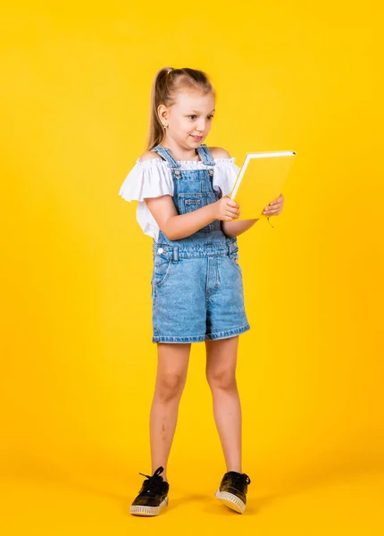 Menina pequena segurar notebook. Leia o livro. Pronto para leitura. lição de literatura. infância feliz. de volta à escola. desenvolvimento de crianças inteligentes. expressar interesse e inteligência — Fotografia de Stock