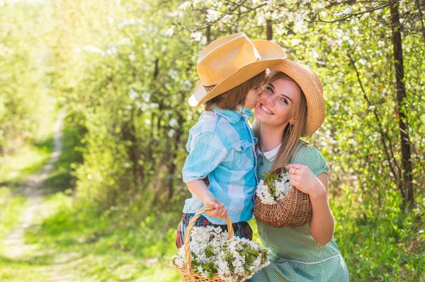 Spend time together. Lovely family outdoors nature background. Farmers in blooming garden. My sweet baby. Ranch concept. Growing flowers. Happy family day. Mother and cute son in hats. Family farm — Stock Photo, Image