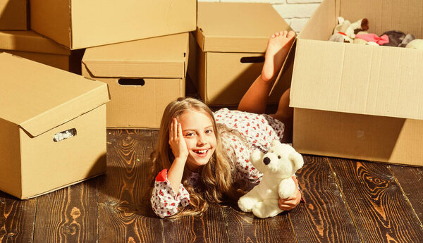 weekends. happy child cardboard box. purchase of new habitation. happy little girl with toy. playing into new home. new apartment. Cardboard boxes - moving to new house