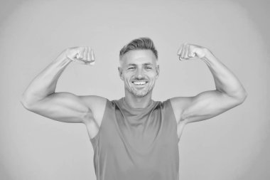 Hayatında güçlü ol. Mutlu sporcu fiziksel güç gösterir. Güçlü adam kollarını mavi arka planda açar. Güçlü pazılar ve trisepsler yapıyorlar. Güçlü kas egzersizi. Spor ve spor. Güçlü ol.