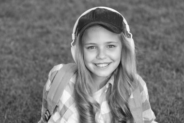 Her anın tadını çıkar. Dışarıda dinlenirken müzik dinlemek. Çocuk yeşil çayır müziğinin tadını çıkarıyor. Keyifli zaman. Çocuk kulaklıkları müzik dinler. Müzik dinleyen kulaklıklar. Eğitici podcast