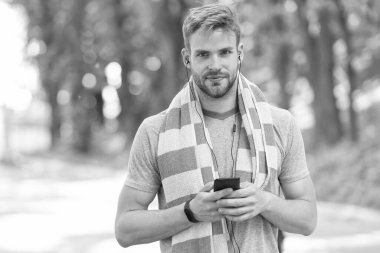 Aktif yaşam tarzın için telefon. Fit adam cep telefonundan müzik dinliyor. Antrenman ve spor eğitimi için telefon uygulamaları kullanıyorum. Modern hayat. Yeni teknoloji. Forma girmek için telefonunu kullan.