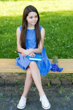 Yaz eğlencesi başladı. Küçük çocuk park bankında oturuyor. Küçük kız yaz günü kitapla rahatlar. Yaz okuma listesi. Yaz tatili. Okul tatili. Dinlenme ve dinlenme