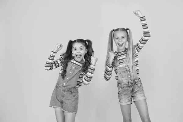 Tiene un gran estilo. Las hermanas pequeñas se divierten. niñas de fondo amarillo. peluquería. moda de verano niño. belleza y estilo. felicidad infantil. feliz amistad escolar. mejores amigos para siempre —  Fotos de Stock