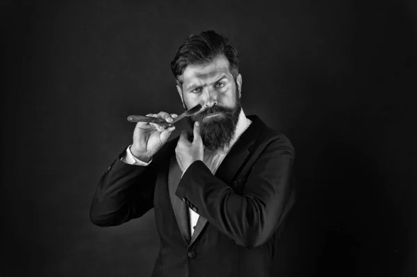 Interested in my hair and my beard. Bearded man shave facial hair. Professional businessman in hair salon. Hipster with mustache and beard hold shaving razor. Barbershop. Hair styling — Stock Photo, Image