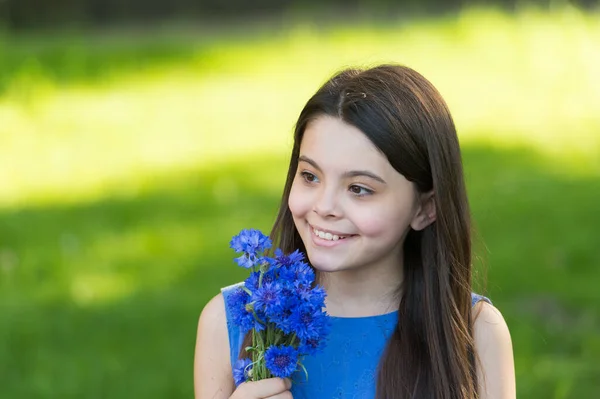 Vackert leende är hälsosamt leende. Glada barn leende på solig dag. Liten flicka med gulligt leende håller sommarblommor. Tandhygien. Tandhälsa. Tandvård. Oral medicin. Var trogen dina tänder — Stockfoto