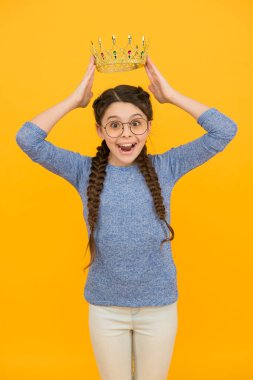 Uzun zamandır beklenen ödül. Küçük akıllı kız gözlük takıyor. Akıllı çocuk. Gözlüklü sevimli kız. Mükemmel bir öğrenci. Başarı ve mutluluk. Prenses kavramı. Kız prenses. Mutlu gülümseme prenses