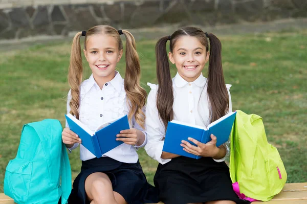 Czytanie jest kluczem. Szczęśliwe dzieci czytają książki na ławce. Dziewczynki lubią czytać na świeżym powietrzu. Czytanie w domu. Rozwijanie wyobraźni. Wiedza i informacje. Popieramy czytanie zjednoczone — Zdjęcie stockowe