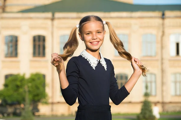 Mijn haar heeft een kapper nodig. Klein meisje met vlechtjes buiten. Gelukkig kind houdt lang blond haar vast. Kapsalon en schoonheidssalon. Haarverzorging en haarstyling. Terug naar school. Behandel je haar vandaag. — Stockfoto