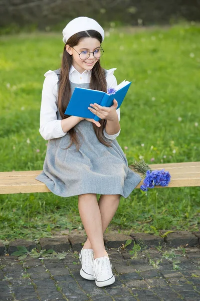 L'entraînement est parfait. Une petite fille a lu un livre sur le banc du parc. Je lis mes devoirs. Devoir. École et éducation. La routine scolaire. Les devoirs développent des habitudes d'étude. Environnement d'apprentissage — Photo